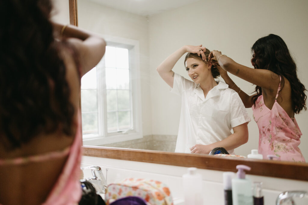 Bride getting ready in her parents’ bedroom at her childhood home before the wedding.